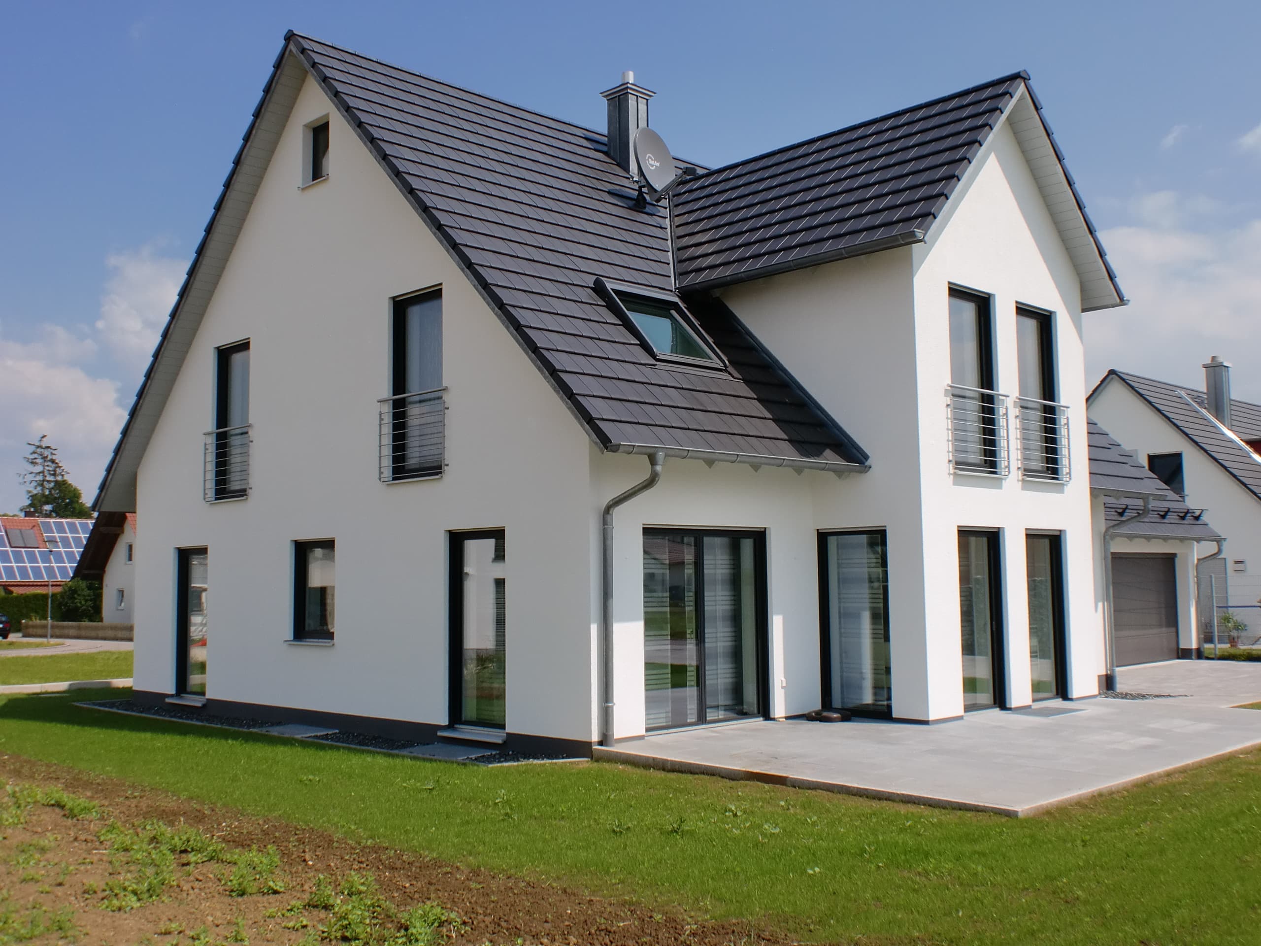 Fertiggestelltes Einfamilienhaus mit verputzter Fassade, Terrasse und Garage